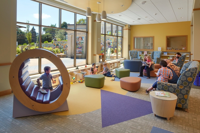 children and their caregivers playing and reading in the children's section of the shrewsbury public library