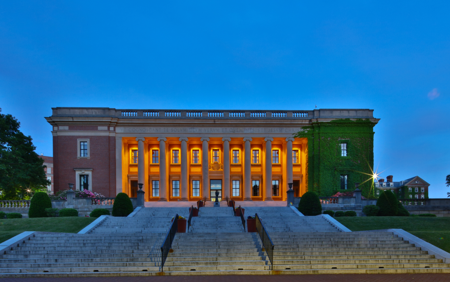 a college library building from the bottom of a large staircase, at dusk