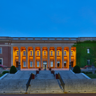 a college library building from the bottom of a large staircase, at dusk