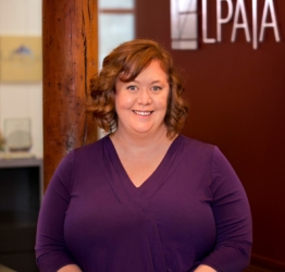 head shot of meghan standing in front of a sign with the LPA|A logo