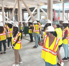 high school girls from the Eureka! program in hard hats tour construction site
