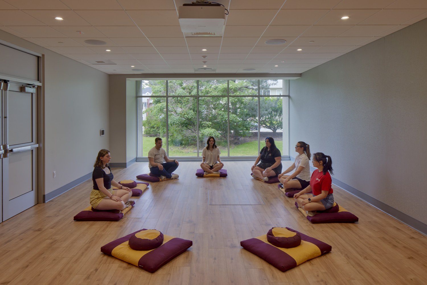 a yoga class with about six people seated in a circle on the floor