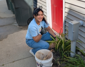 a woman working in a garden gives a thumbs up