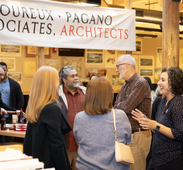 a party scene in an office with small groups of people in conversation