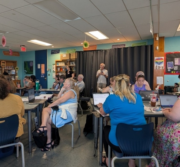 People gathered at tables in a school classroom